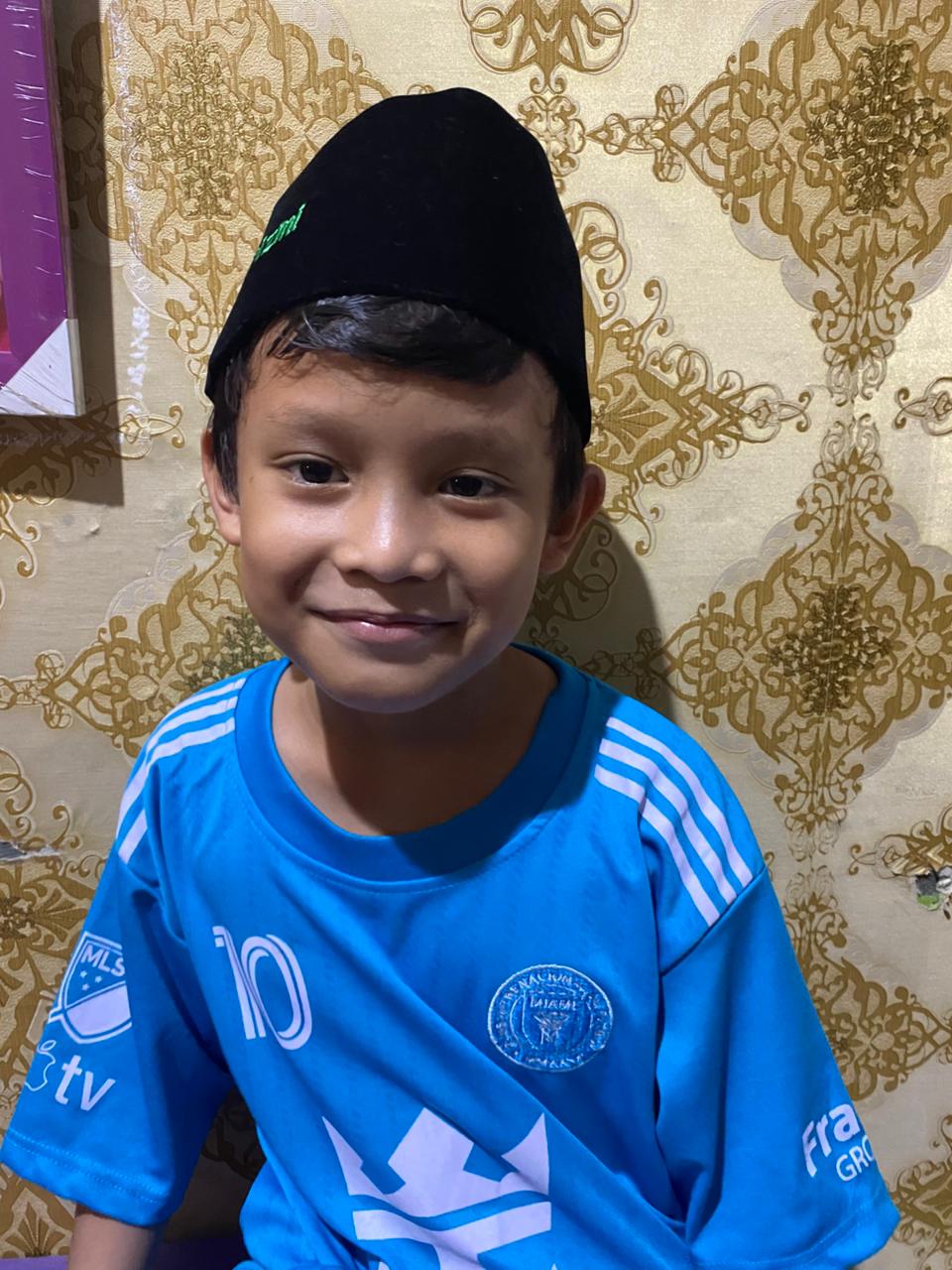 Syamil wearing a black hat and blue t-shirt